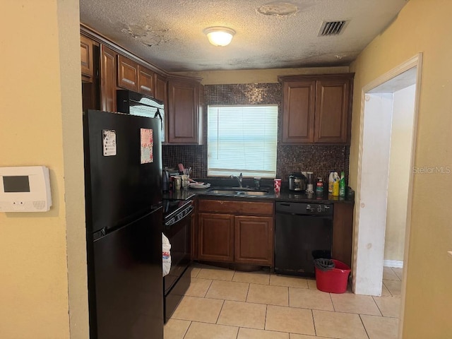 625 E Jackson Ave, Mount Dora, FL 32757 - kitchen featuring black appliances, backsplash, dark countertops, a sink, and light tile patterned floors