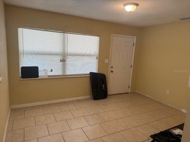 625 E Jackson Ave, Mount Dora, FL 32757 - unfurnished room with a textured ceiling, light tile patterned floors, and baseboards