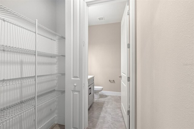 1262 Champions Dr, Daytona Beach, FL 32124 - bathroom with toilet, baseboards, and vanity