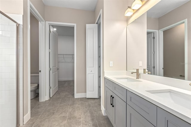 1262 Champions Dr, Daytona Beach, FL 32124 - bathroom with toilet, double vanity, tiled shower, baseboards, and a spacious closet