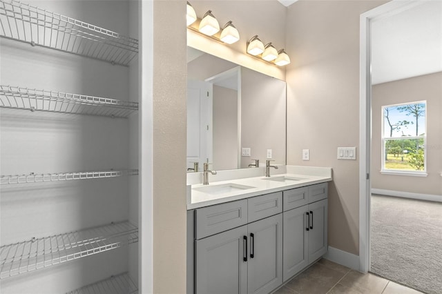1262 Champions Dr, Daytona Beach, FL 32124 - bathroom with double vanity, baseboards, tile patterned flooring, and a walk in closet