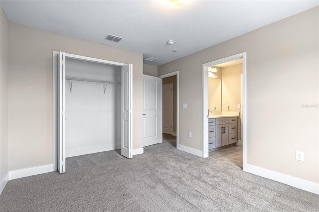 1262 Champions Dr, Daytona Beach, FL 32124 - unfurnished bedroom with light colored carpet, a closet, baseboards, and connected bathroom