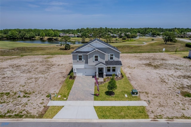 1262 Champions Dr, Daytona Beach, FL 32124 - view of front of property featuring a water view, driveway, an attached garage, a front lawn, and view of scattered trees