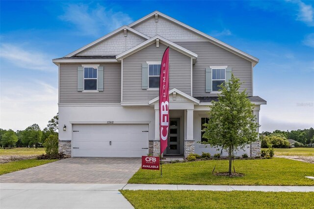 1262 Champions Dr, Daytona Beach, FL 32124 - view of front of property featuring stone siding, an attached garage, a front yard, and driveway
