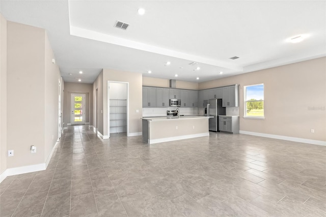 1262 Champions Dr, Daytona Beach, FL 32124 - kitchen featuring gray cabinets, appliances with stainless steel finishes, open floor plan, healthy amount of natural light, and recessed lighting