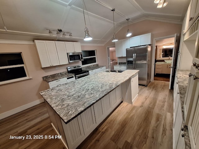 6505 Oelsner St, New Port Richey, FL 34652 - kitchen with stainless steel appliances, an island with sink, lofted ceiling, light stone countertops, and light wood-type flooring