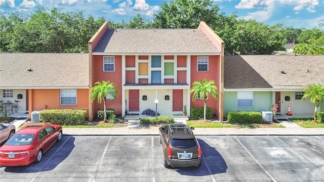 4952 Tangerine Ave Unit 4952, Winter Park, FL 32792 - view of property featuring a shingled roof, central AC unit, uncovered parking, and stucco siding