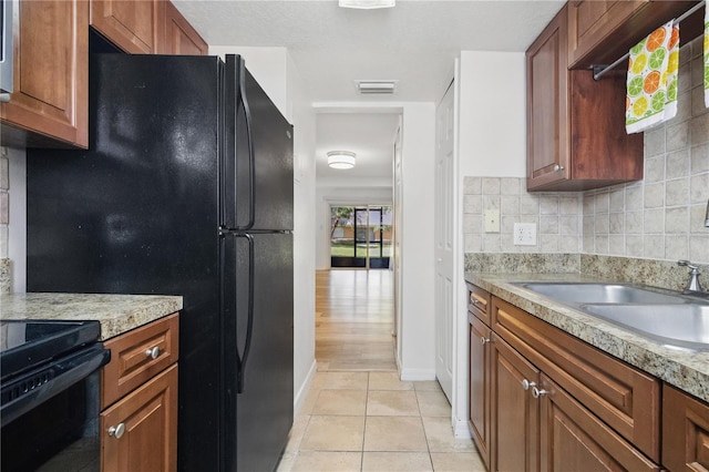 4952 Tangerine Ave Unit 4952, Winter Park, FL 32792 - kitchen with black appliances, light tile patterned floors, light countertops, and baseboards