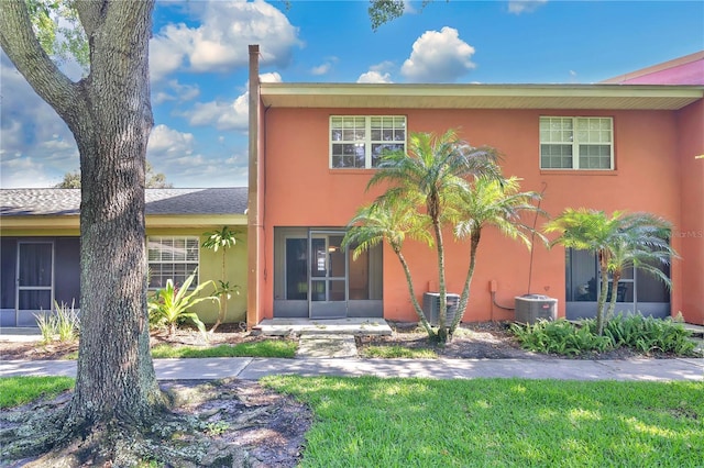 4952 Tangerine Ave Unit 4952, Winter Park, FL 32792 - view of front of house with stucco siding, a sunroom, central air condition unit, and a front lawn