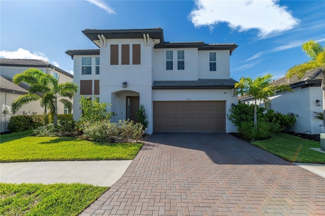 4861 Antrim Dr, Sarasota, FL 34240 - view of front of home with an attached garage, decorative driveway, stucco siding, and a front yard