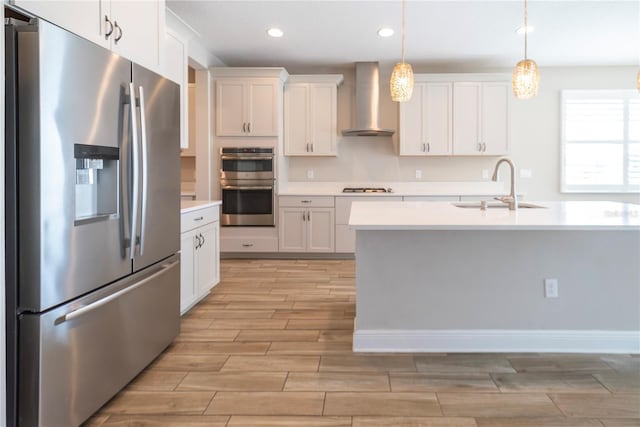 4861 Antrim Dr, Sarasota, FL 34240 - kitchen with appliances with stainless steel finishes, wall chimney range hood, light wood finished floors, light countertops, and recessed lighting