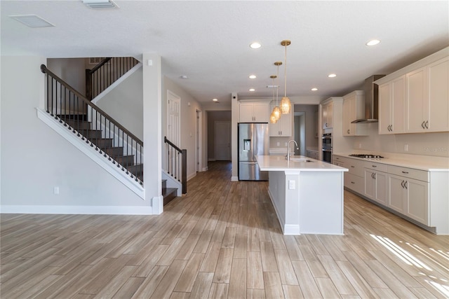 4861 Antrim Dr, Sarasota, FL 34240 - kitchen featuring appliances with stainless steel finishes, wall chimney exhaust hood, recessed lighting, light wood-style flooring, and light countertops