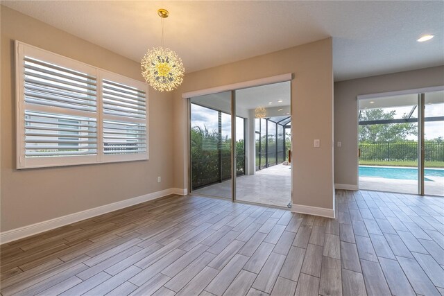 4861 Antrim Dr, Sarasota, FL 34240 - empty room with wood finished floors, a chandelier, and recessed lighting