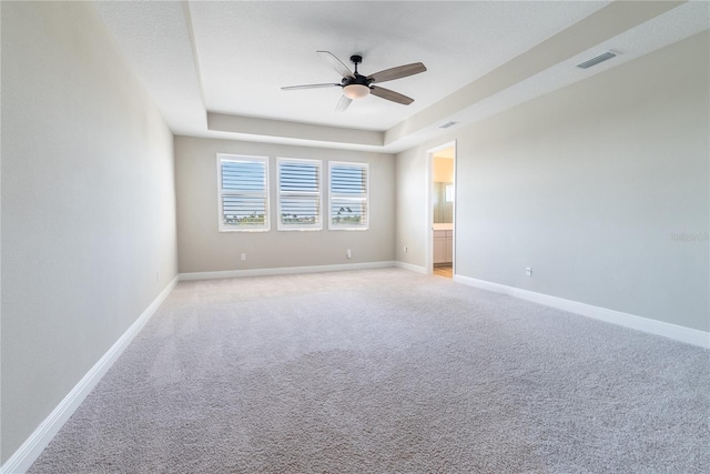 4861 Antrim Dr, Sarasota, FL 34240 - spare room featuring ceiling fan, light carpet, and a tray ceiling