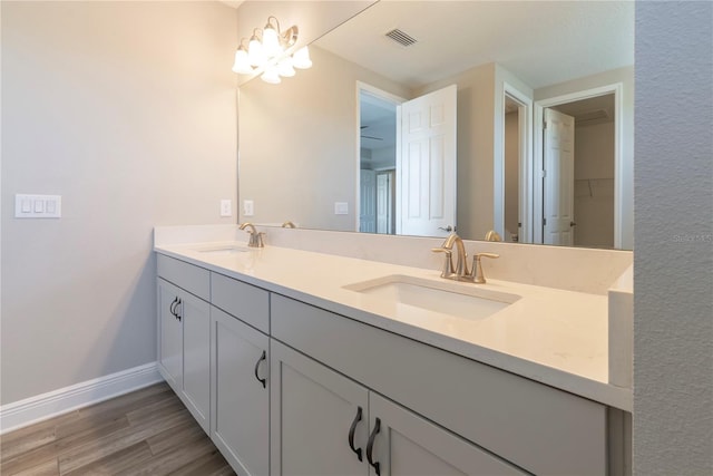 4861 Antrim Dr, Sarasota, FL 34240 - bathroom with double vanity, wood finished floors, and a chandelier