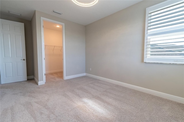 4861 Antrim Dr, Sarasota, FL 34240 - unfurnished bedroom with carpet flooring, a walk in closet, multiple windows, and a closet