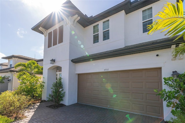 4861 Antrim Dr, Sarasota, FL 34240 - view of front of property featuring an attached garage, stucco siding, and decorative driveway