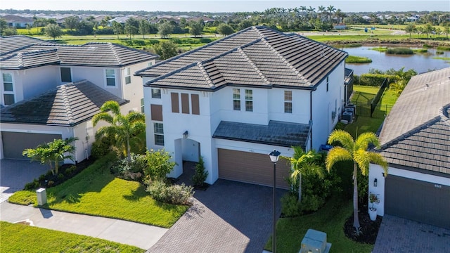 4861 Antrim Dr, Sarasota, FL 34240 - view of front of property featuring decorative driveway, stucco siding, an attached garage, a tiled roof, and a water view