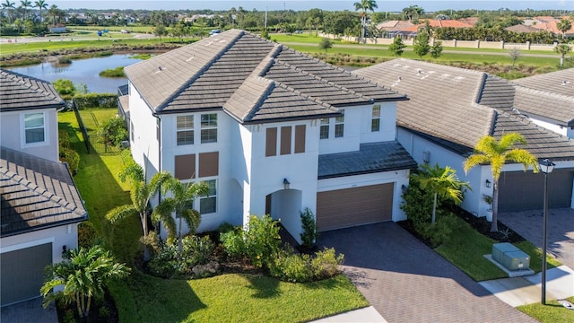 4861 Antrim Dr, Sarasota, FL 34240 - view of front of property featuring stucco siding, decorative driveway, a tiled roof, a water view, and an attached garage