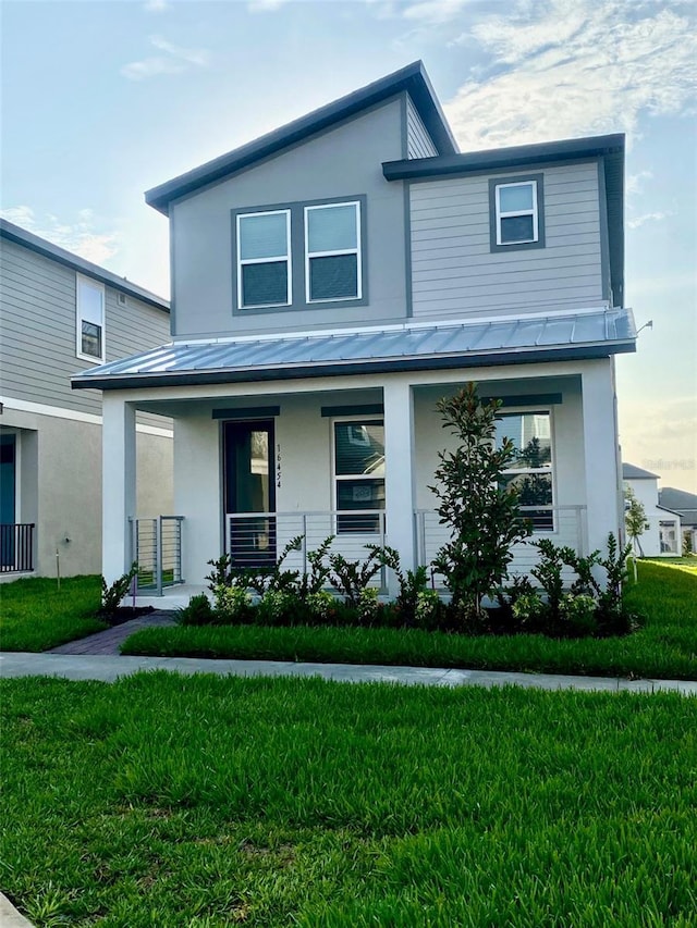 16454 Silver Brook Way, Winter Garden, FL 34787 - view of front facade featuring a standing seam roof, stucco siding, covered porch, metal roof, and a front yard