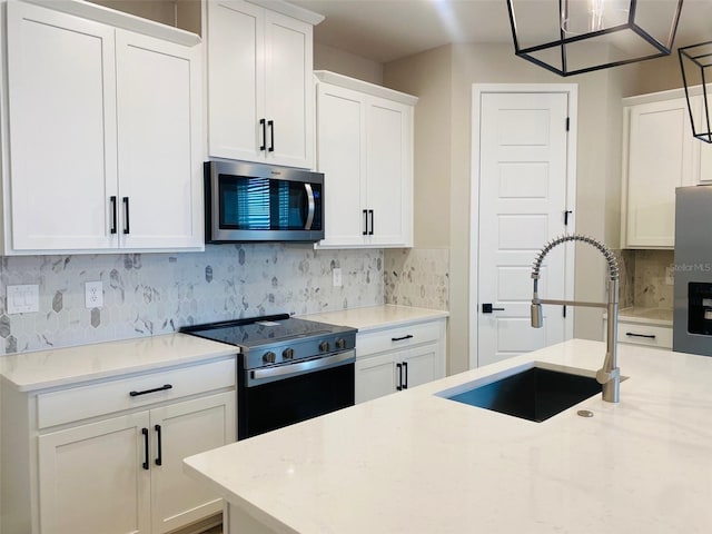 16454 Silver Brook Way, Winter Garden, FL 34787 - kitchen with stainless steel appliances, a sink, white cabinets, backsplash, and light stone counters