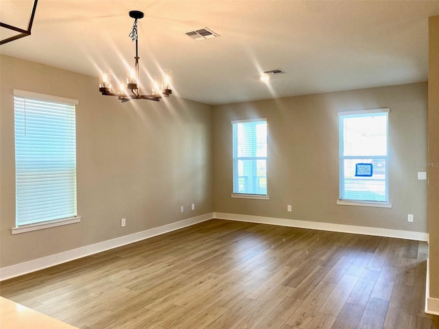16454 Silver Brook Way, Winter Garden, FL 34787 - spare room featuring a chandelier, wood finished floors, baseboards, and plenty of natural light