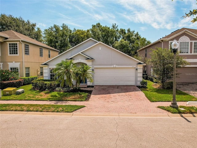 879 Nonastone Run, Casselberry, FL 32707 - view of front of home featuring decorative driveway, a garage, stucco siding, and a front lawn