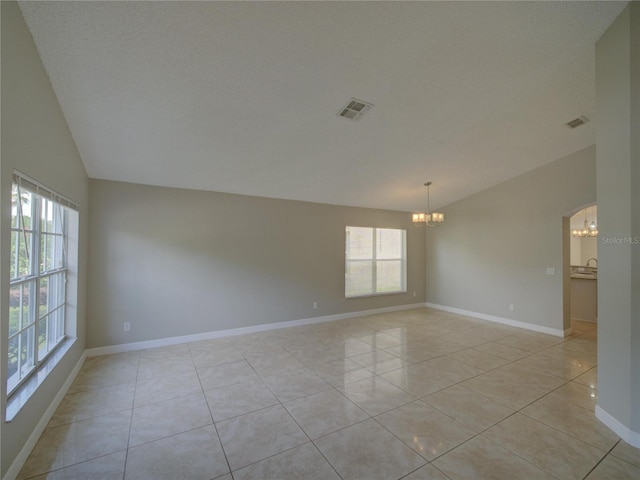 879 Nonastone Run, Casselberry, FL 32707 - spare room with a chandelier, vaulted ceiling, light tile patterned floors, and baseboards