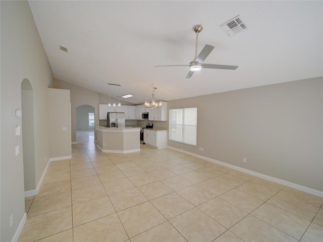 879 Nonastone Run, Casselberry, FL 32707 - unfurnished living room featuring arched walkways, lofted ceiling, ceiling fan, a chandelier, and light tile patterned floors