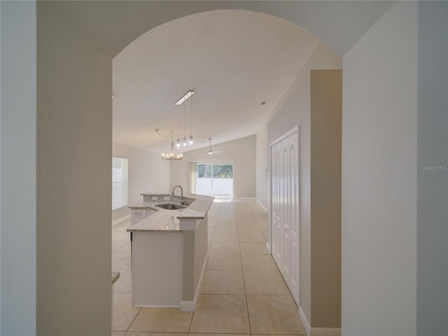 879 Nonastone Run, Casselberry, FL 32707 - hall with a sink, light tile patterned floors, vaulted ceiling, a chandelier, and arched walkways