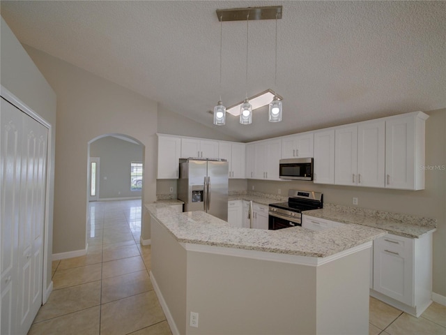 879 Nonastone Run, Casselberry, FL 32707 - kitchen with stainless steel appliances, arched walkways, light tile patterned floors, lofted ceiling, and a textured ceiling