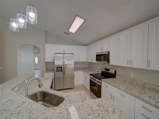 879 Nonastone Run, Casselberry, FL 32707 - kitchen with appliances with stainless steel finishes, a sink, vaulted ceiling, arched walkways, and white cabinets