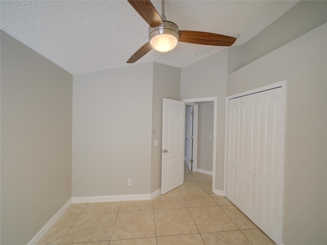 879 Nonastone Run, Casselberry, FL 32707 - unfurnished bedroom with light tile patterned floors, a textured ceiling, a closet, a ceiling fan, and baseboards