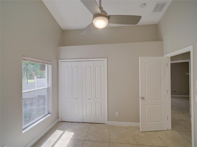 879 Nonastone Run, Casselberry, FL 32707 - unfurnished bedroom featuring light tile patterned floors, a closet, baseboards, and a ceiling fan