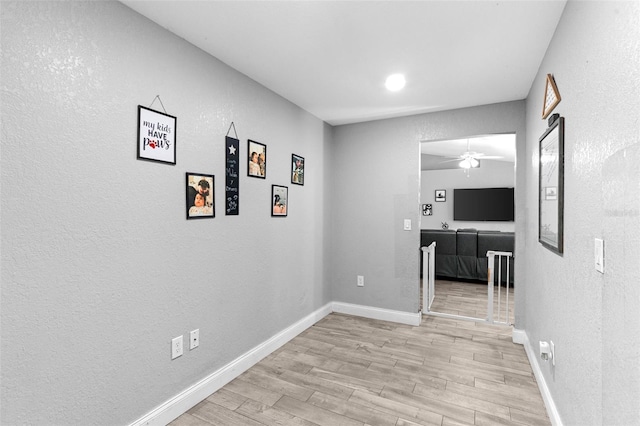 122 Seville Rd, Auburndale, FL 33823 - corridor with light wood finished floors, a textured wall, and baseboards