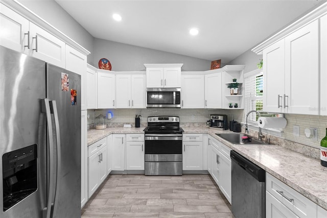 122 Seville Rd, Auburndale, FL 33823 - kitchen featuring appliances with stainless steel finishes, a sink, lofted ceiling, white cabinetry, and decorative backsplash