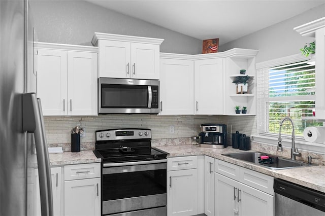 122 Seville Rd, Auburndale, FL 33823 - kitchen with appliances with stainless steel finishes, a sink, open shelves, decorative backsplash, and vaulted ceiling
