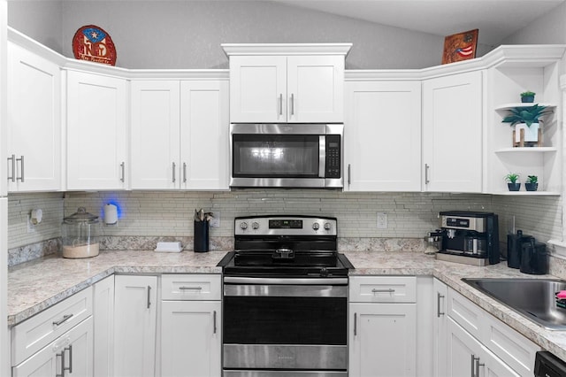 122 Seville Rd, Auburndale, FL 33823 - kitchen featuring appliances with stainless steel finishes, open shelves, white cabinets, light countertops, and lofted ceiling