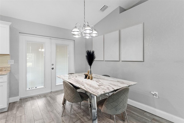 122 Seville Rd, Auburndale, FL 33823 - dining room with a chandelier, light wood-style flooring, baseboards, french doors, and vaulted ceiling