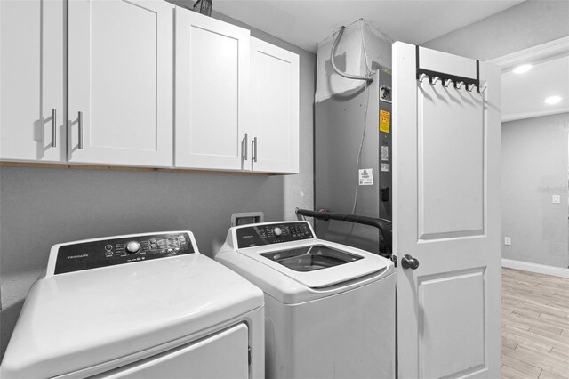 122 Seville Rd, Auburndale, FL 33823 - laundry area featuring cabinet space, washing machine and clothes dryer, light wood finished floors, and baseboards