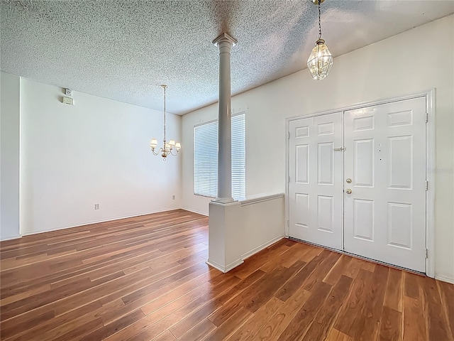 1131 Turtle Lake Ct, Ocoee, FL 34761 - foyer featuring a chandelier, wood finished floors, decorative columns, and a textured ceiling