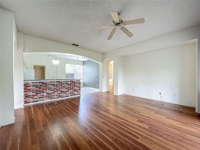 1131 Turtle Lake Ct, Ocoee, FL 34761 - unfurnished living room featuring wood finished floors, a textured ceiling, arched walkways, and a ceiling fan