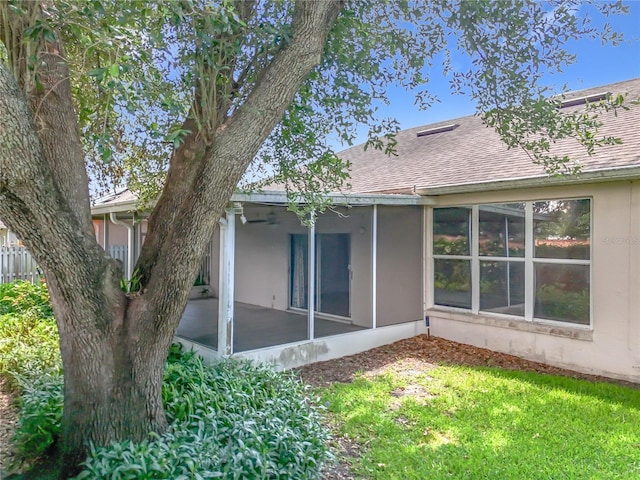1131 Turtle Lake Ct, Ocoee, FL 34761 - back of house featuring a sunroom, roof with shingles, stucco siding, and a lawn