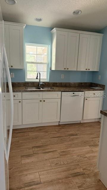 30965 E Thyme Ave, Eustis, FL 32736 - kitchen featuring dishwasher, white cabinets, a sink, dark countertops, and recessed lighting