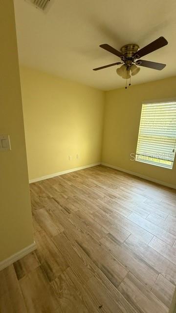 30965 E Thyme Ave, Eustis, FL 32736 - empty room with a ceiling fan, wood finished floors, and baseboards