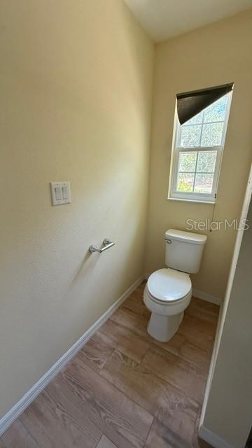 30965 E Thyme Ave, Eustis, FL 32736 - bathroom featuring toilet, wood finished floors, and baseboards