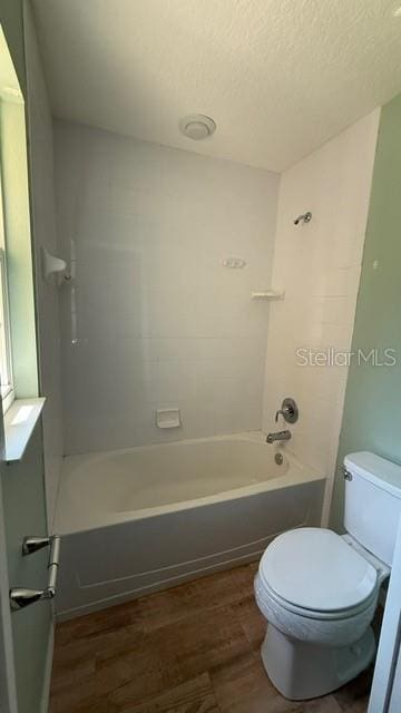 30965 E Thyme Ave, Eustis, FL 32736 - bathroom featuring toilet, wood finished floors, bathtub / shower combination, and a textured ceiling