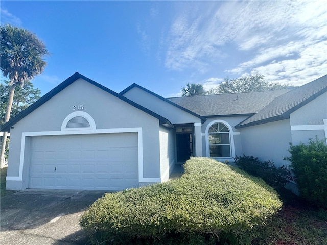215 Hollowbrook Cir, Daytona Beach, FL 32114 - ranch-style home with a shingled roof, stucco siding, asphalt driveway, and a garage