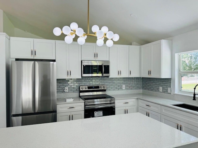215 Hollowbrook Cir, Daytona Beach, FL 32114 - kitchen featuring appliances with stainless steel finishes, a sink, vaulted ceiling, a chandelier, and tasteful backsplash