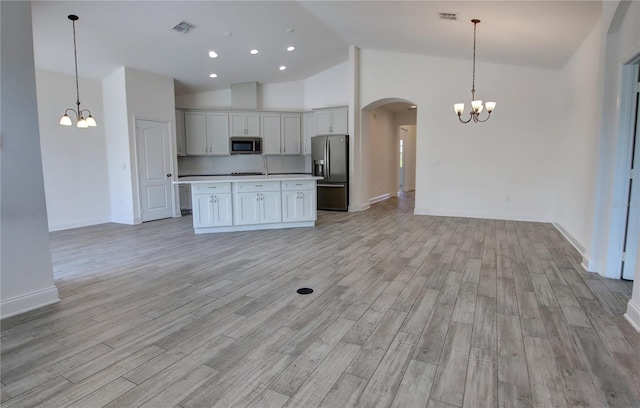 1727 Butterfly Way, Longwood, FL 32750 - kitchen with appliances with stainless steel finishes, a chandelier, open floor plan, arched walkways, and high vaulted ceiling